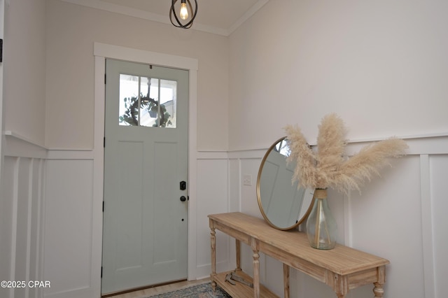 entryway featuring a decorative wall, a wainscoted wall, and ornamental molding