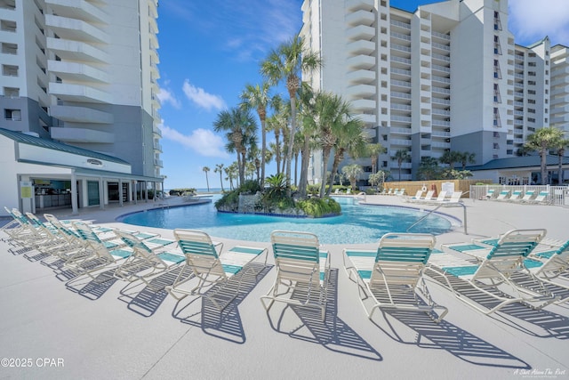 pool with a patio area and fence