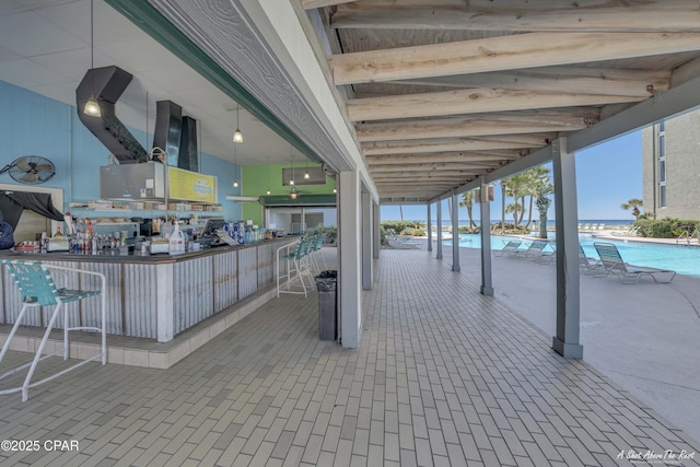 view of patio / terrace featuring a community pool and outdoor dry bar