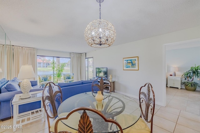 dining space with light tile patterned floors, a notable chandelier, a textured ceiling, and baseboards