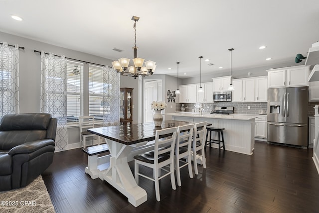 dining room with an inviting chandelier, visible vents, dark wood finished floors, and recessed lighting