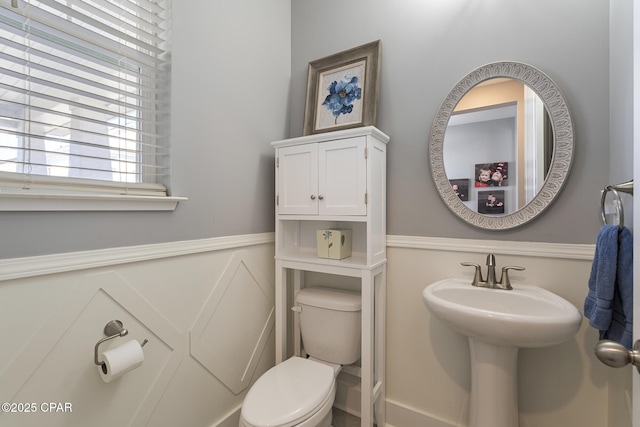 half bath with wainscoting and toilet