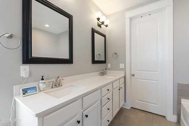 full bathroom featuring double vanity, a washtub, a sink, and tile patterned floors