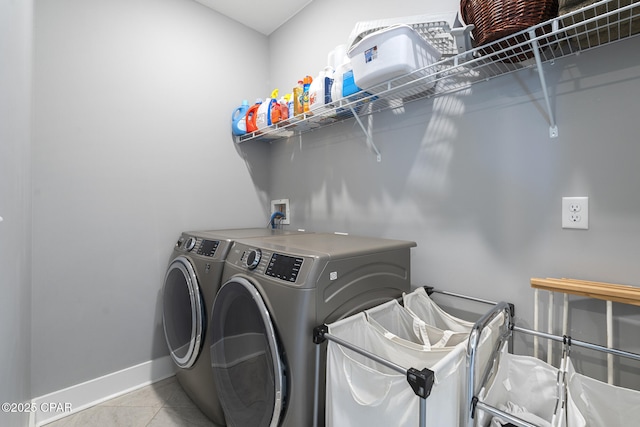 washroom featuring laundry area, washing machine and dryer, baseboards, and tile patterned flooring