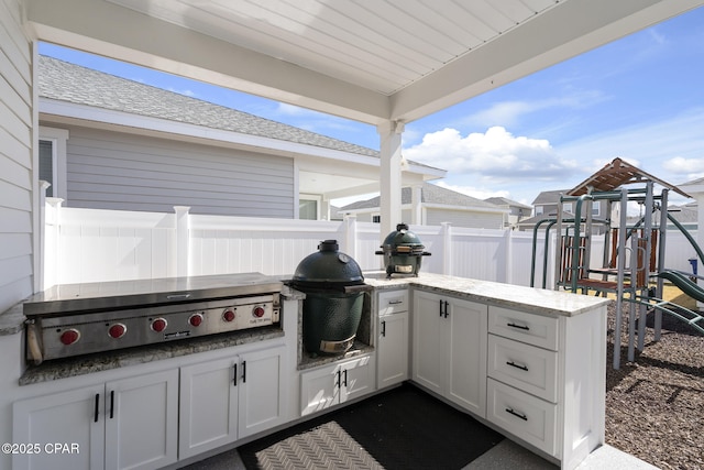 view of patio / terrace featuring a playground, fence, and area for grilling