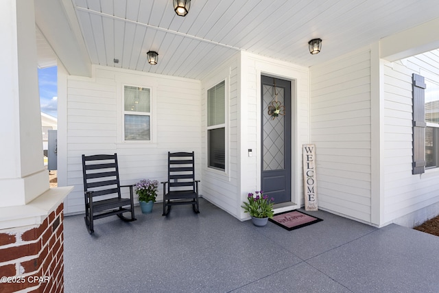 view of exterior entry featuring covered porch