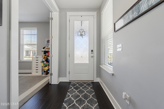 foyer entrance featuring baseboards and dark wood-type flooring