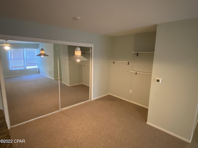 unfurnished bedroom featuring a closet, baseboards, and carpet floors