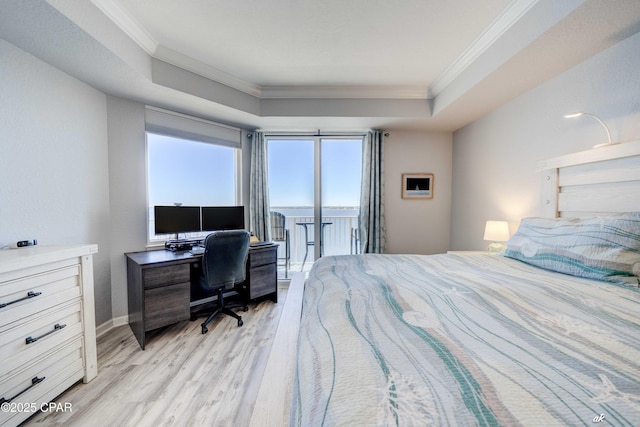 bedroom featuring a tray ceiling, light wood-style floors, access to exterior, and crown molding