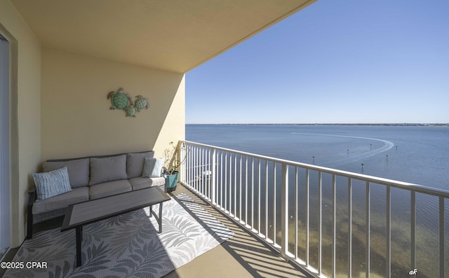 balcony featuring an outdoor living space and a water view