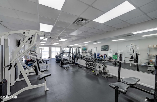 exercise room featuring baseboards, visible vents, and a drop ceiling