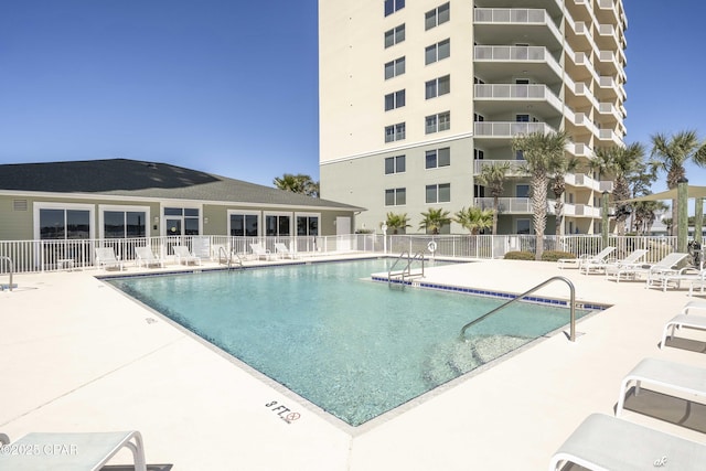 community pool featuring a patio and fence