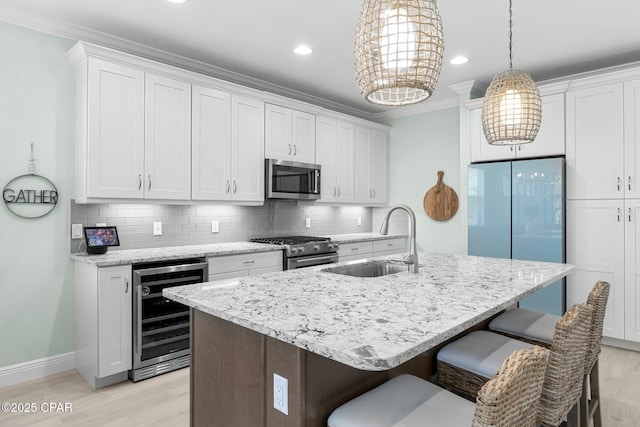 kitchen featuring wine cooler, decorative backsplash, appliances with stainless steel finishes, and a sink