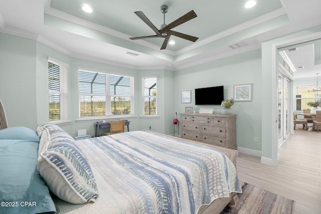 bedroom featuring visible vents, a raised ceiling, wood finished floors, and crown molding