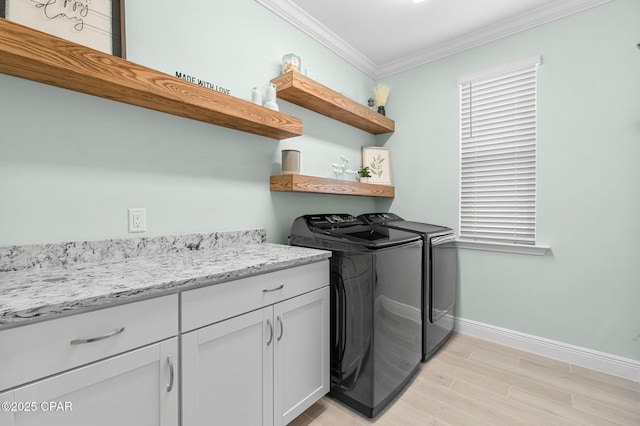 laundry room with ornamental molding, washer and dryer, cabinet space, light wood finished floors, and baseboards