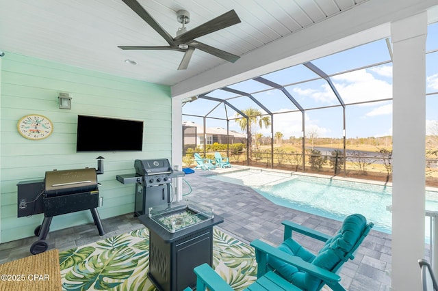 view of patio with grilling area, glass enclosure, an outdoor pool, and ceiling fan