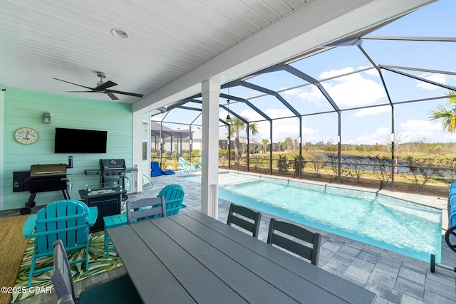 outdoor pool with a patio area, glass enclosure, and a ceiling fan