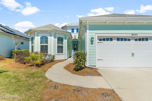 view of front of home featuring concrete driveway and an attached garage