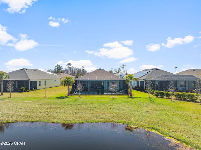 rear view of property with a water view and a lawn