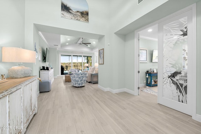 corridor with baseboards, light wood finished floors, high vaulted ceiling, recessed lighting, and crown molding