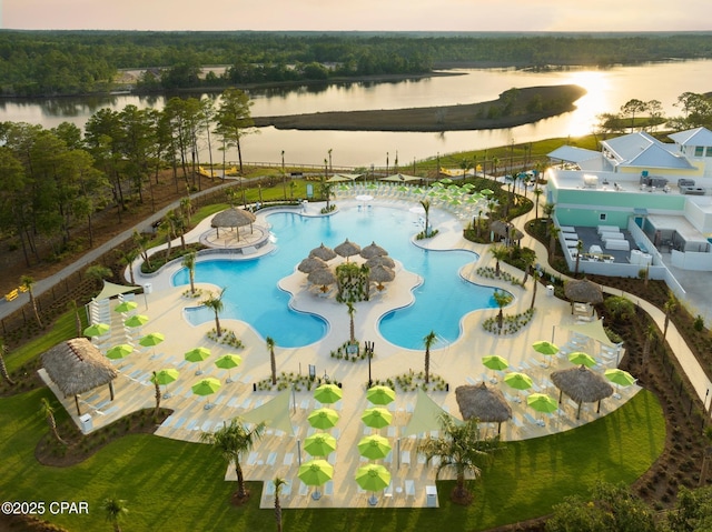 pool featuring a water view and a patio area