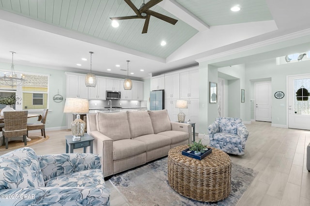 living room with beam ceiling, a healthy amount of sunlight, baseboards, and light wood-style floors