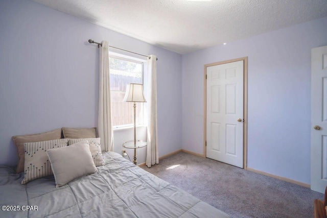 bedroom with baseboards, carpet floors, and a textured ceiling