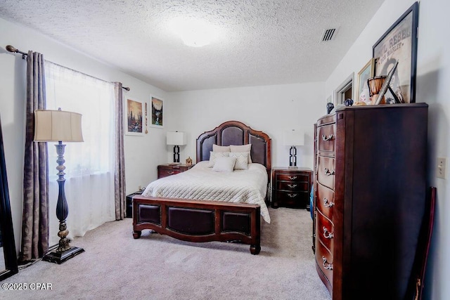 carpeted bedroom with visible vents and a textured ceiling