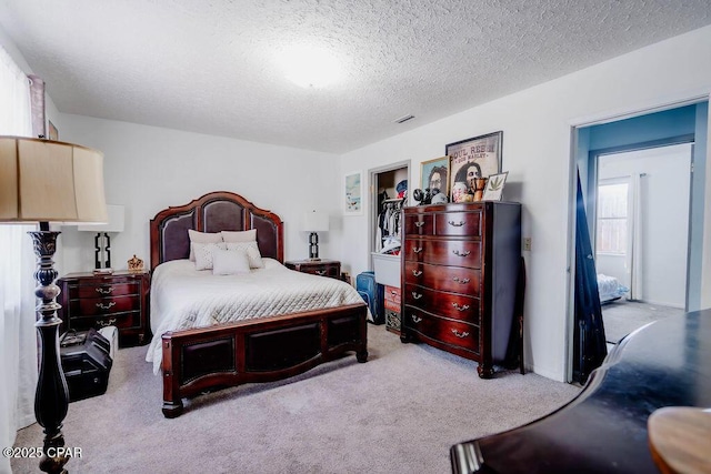 bedroom featuring visible vents, a textured ceiling, and carpet floors