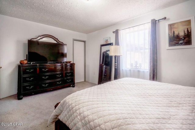 carpeted bedroom featuring a closet and a textured ceiling