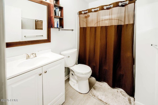 bathroom featuring vanity, curtained shower, and toilet