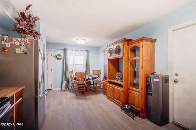 dining area with baseboards and light wood-type flooring