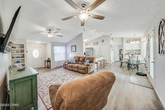 1705 Rhett Pl, Lynn Haven, FL 32444 - living area featuring a ceiling fan, lofted ceiling, a textured ceiling, light wood-type flooring, and a chandelier
