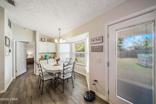 1705 Rhett Pl, Lynn Haven, FL 32444 - dining area featuring a textured ceiling, a chandelier, dark wood-style floors, vaulted ceiling, and baseboards