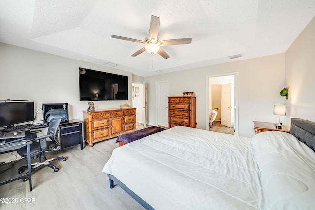 1705 Rhett Pl, Lynn Haven, FL 32444 - bedroom with wood finished floors, an office area, a tray ceiling, ceiling fan, and a textured ceiling
