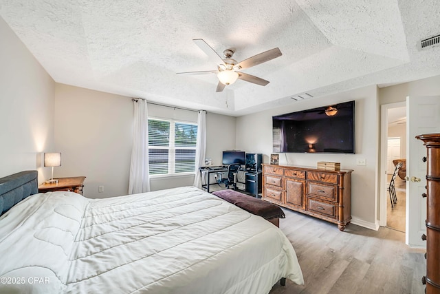 1705 Rhett Pl, Lynn Haven, FL 32444 - bedroom featuring a textured ceiling, wood finished floors, ceiling fan, baseboards, and a raised ceiling