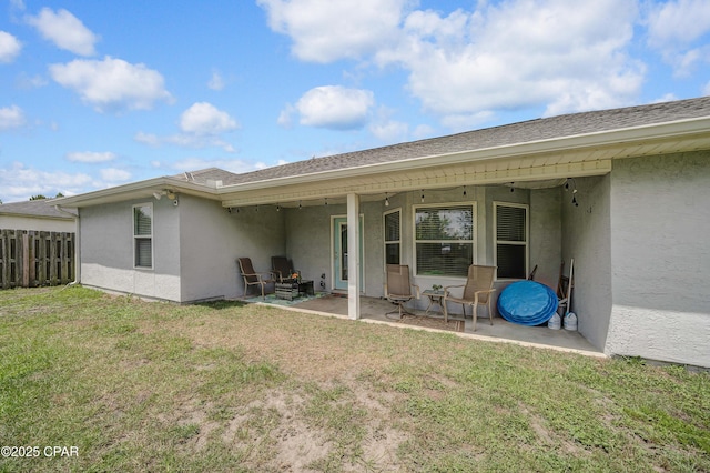 1705 Rhett Pl, Lynn Haven, FL 32444 - back of property featuring stucco siding, a patio area, and a shingled roof