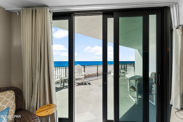 entryway featuring a wall of windows, a water view, and plenty of natural light