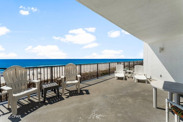 view of patio / terrace featuring a beach view and a water view