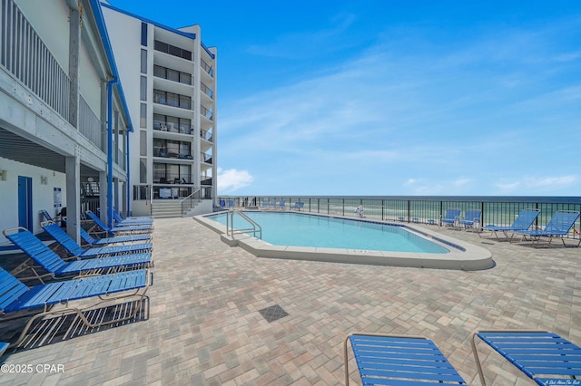 community pool featuring a patio area and a water view