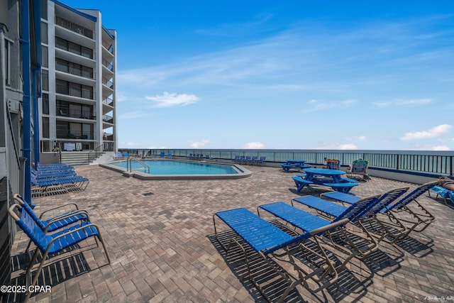 community pool featuring a patio and a water view