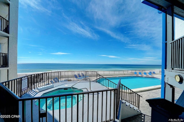 community pool featuring a water view and a hot tub