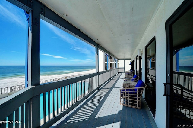 balcony featuring a water view and a view of the beach