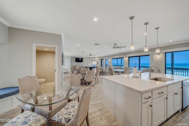 kitchen featuring a sink, white cabinets, wood tiled floor, and crown molding