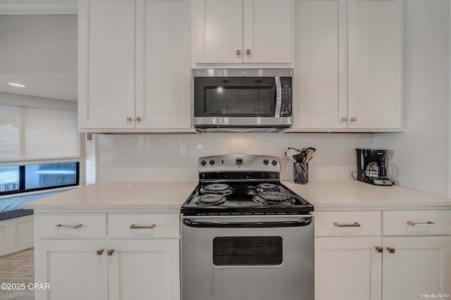 kitchen with white cabinets, appliances with stainless steel finishes, and light countertops