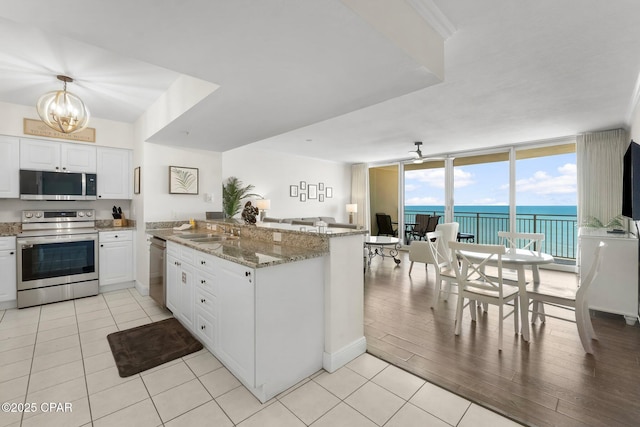 14701 Front Beach Rd Unit 1934, Panama City Beach, FL 32413 - kitchen featuring white cabinetry, expansive windows, a sink, a peninsula, and appliances with stainless steel finishes