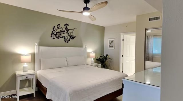 bedroom featuring visible vents, baseboards, dark wood-style flooring, and a ceiling fan