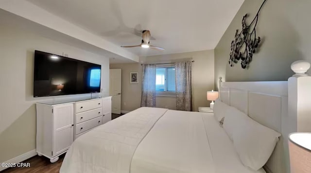 bedroom with dark wood finished floors, a ceiling fan, and baseboards