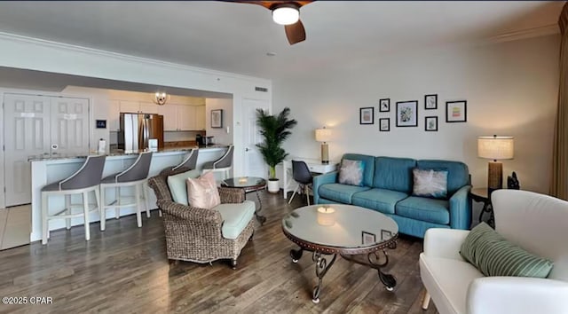 living room featuring dark wood-type flooring and a ceiling fan