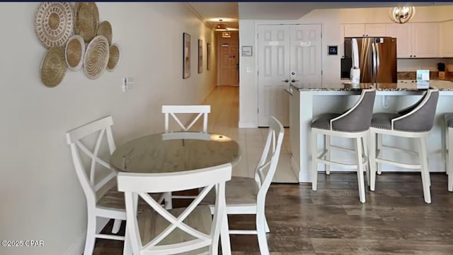 dining space with baseboards and wood finished floors